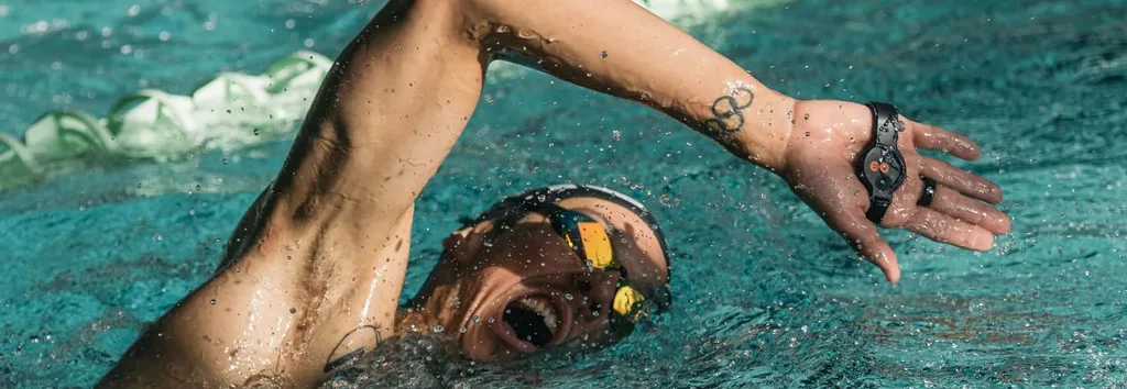 Пловец выполняет гребок кролем с датчиком SwimBETTER90 для измерения мощности и анализа техники плавания.